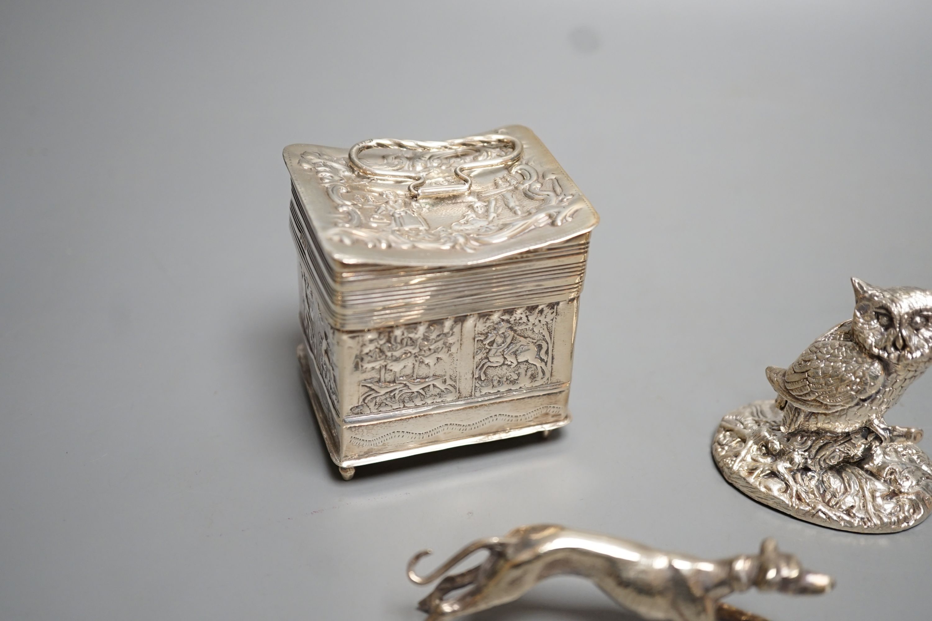 A continental embossed silver box, with import marks for London, 1903, 65mm, a modern silver filled model owl and a metal model of a dog.